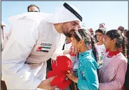  ??  ?? Emirati singer Hussein al-Jasmi (left), distribute­s soft toys to Iraqi children during a visit on behalf of Emirates Red Crescent at the Dibaga camp for displaced Iraqis who fled the violence in the northern city of Mosul, on April 2, in Makhmur, about 280 kms (175 miles) north of the capital Baghdad.