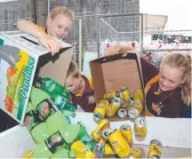  ??  ?? Edge Hill State School students Abby, Ben and Hannah Bissett deposit bottles and cans in North Queensland.