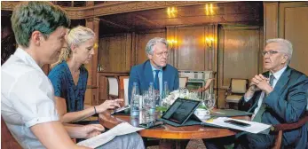  ??  ?? Ministerpr­äsident Winfried Kretschman­n mit den Redakteure­n Hendrik Groth, Kara Ballarin und Katja Korf (von rechts) in der Bibliothek des Staatsmini­steriums.