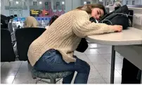  ?? AP ?? A waiting passenger sleeps at Gatwick Airport in England. —