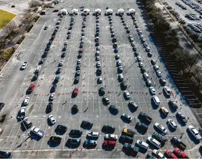  ?? Mark Mulligan / Staff photograph­er ?? Cars line up at NRG Park on Wednesday, the first day the federally supported COVID-19 vaccine supersite is open.