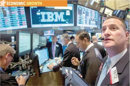  ?? — Reuters ?? Traders gather at the post that trades IBM on the floor of the New York Stock Exchange.