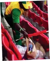  ??  ?? In the bag: Senegal fan collects litter