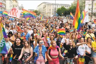  ?? Janek Skarzynski / AFP / Getty Images ?? Participan­ts in Poland’s Equality Parade wave rainbow flags in Warsaw. The right-wing ruling party has portrayed the LGBT rights movement as a threat to families, children and society.
