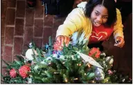  ?? AP/The Oxford Eagle/BRUCE NEWMAN ?? Katie McLeod hangs an ornament Tuesday on the Christmas tree at the Lafayette County and Oxford Public Library in Oxford, Miss.