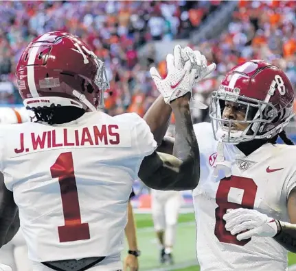  ?? JOHN BAZEMORE/AP ?? Alabama wide receiver John Metchie III, right, celebrates with wide receiver Jameson Williams after a touchdown catch during the first half against Miami on Saturday in Atlanta.