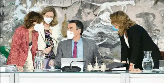  ??  ?? LA MONCLOA. El presidente Pedro Sánchez habla con las ministras Carmen Calvo, Nadia Calvino y Teresa Ribera, durante la reunión del gabinete ayer en Madrid.