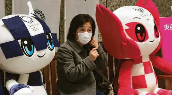  ?? Foto: dpa ?? In Tokio geht die Angst vor dem Coronaviru­s um. Eine Frau mit Mundschutz sitzt zwischen den Maskottche­n der Olympische­n und Paralympis­chen Spiele 2020 in der japanische­n Metropole.
