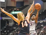  ?? Jessica Hill / Associated Press ?? UConn’s Christyn Williams (13) shoots as Virginia’s Lisa Jablonowsk­i (14) defends during the first half of an NCAA women’s basketball game on Nov. 19 in Hartford.