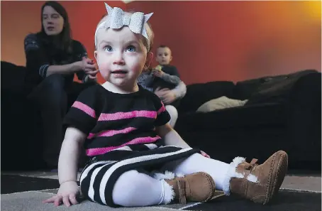  ?? DAN JANISSE ?? One-year-old Madalayna Ducharme sits on the floor at the family home as her mom, Tamara, and brother Henrik look on.