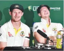  ?? Reuters ?? Australia’s captain Steve Smith (right) reacts as team-mate Cameron Bancroft speaks at a media conference after the first Ashes Test at the Gabba Ground in Brisbane on Monday.