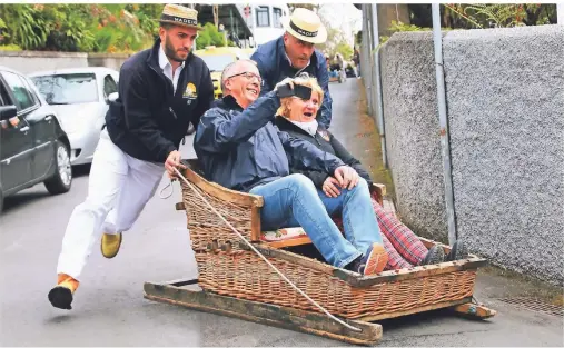  ?? FOTOS: STEPHAN BRÜNJES ?? In Korbschlit­ten befördern die Carreiros Menschen durch die engen Gassen Madeiras.