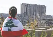  ?? AFP VIA GETTY IMAGES ?? A youth looks at damaged grain silos at Beirut’s port, on Tuesday, which were destroyed in last week’s blast.