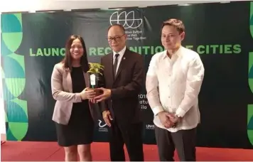  ?? CSF-CIO ?? GREEN AWARD. DBM Secretary Benjamin Diokno and Senator Sonny Angara extend the green award to City Engineer’s Office OIC Anele David for San Fernando’s sustainabl­e greening projects.—