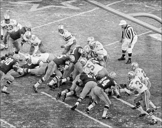  ?? The Associated Press ?? Packers quarterbac­k Bart Starr, center, bulls his way into the end zone to give Green Bay a 21-17 victory over the Dallas Cowboys in the “Ice Bowl” — the NFL championsh­ip game played Dec. 31, 1967, at Lambeau Field in Green Bay, Wis.