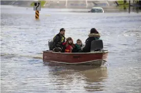  ?? British Columbia. Photograph: Darryl Dyck/AP ?? A woman and children who were stranded by high water are rescued in Abbotsford,