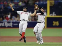  ?? THE ASSOCIATED PRESS ?? Boston Red Sox shortstop Xander Bogaerts, left, loses his balance as he makes a catch on a pop out by Tampa Bay Rays’ Mike Zunino in front of teammate third baseman Rafael Devers during the third inning of a baseball game Wednesday, July 24, 2019, in St. Petersburg, Fla.