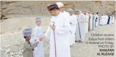  ?? KHALFAN AL RUZAIQI ?? Children receive Eidiya from elders in Amerat on Friday. PHOTO BY