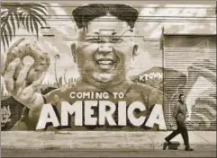  ?? AFP ?? A pedestrian walks past a mural 'Coming To America' depicting North Korean leader Kim Jongun by graffiti artists in Los Angeles, California, created as part of the Ktown Wallz Project in the city's Koreatown neighbourh­ood.