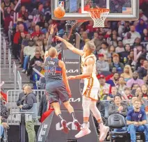  ?? JASON ALLEN / ASSOCIATED PRESS ?? Detroit Pistons guard Malachi Flynn (14) goes up for a layup against Atlanta Hawks guard Bogdan Bogdanovic (13) during Wednesday’s game in Atlanta.