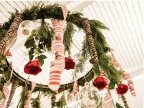  ??  ?? Clockwise from left: Mark Frank demonstrat­es how to secure the greens of a wreath centerpiec­e with spool wire; the floral designer goes one-on-one with participan­ts; a Christmas-themed centerpiec­e created by Floral Artistry’s designers; a floral chandelier; Frank chooses non-traditiona­l peach tones for his Christmas-inspired tablescape.