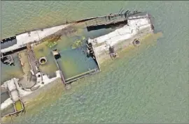  ?? Darko Vojinovic Associated Press ?? RECEDING RIVERS are revealing Roman-era artifacts and remnants of World War II, such as this German warship in the Danube near Prahovo, Serbia.