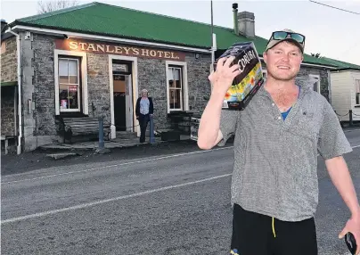  ?? PHOTO: LINDA ROBERTSON ?? Cool and collected . . . Middlemarc­h farm worker Jock van Asch picks up his clickandco­llect purchase from Stanley’s Hotel, at Macraes, on Friday night. In the background is Macraes Community Developmen­t Trust trustee Tricia Harvie.