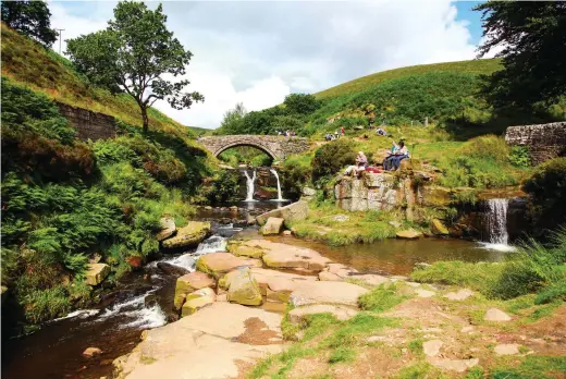  ??  ?? ABOVE A Grade II-listed packhorse bridge spans the River Dane and its cooling pools at Three Shires Head BELOW Looking south from the hillside above Three Shires Head towards The Roaches, a prominent gritstone ridge said to be the home of a wicked mermaid known as Jenny Greenteeth