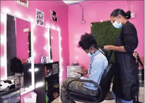  ?? Arnold Gold / Hearst Connecticu­t Media ?? Tabyra Murdock-Washington gives Tiera Hart of Hamden extension braids at her hair salon, The Brya Collection, in Hamden on Wednesday.