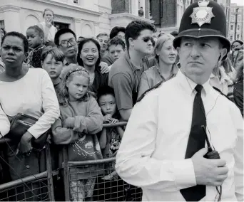  ??  ?? La città Londra, agosto 1995: un poliziotto in divisa controlla la folla alla parata del carnevale Notting Hill, storico appuntamen­to cittadino della capitale inglese