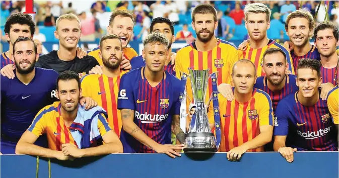  ??  ?? MIAMI GARDENS: Barcelona celebrate with the trophy after defeating Real Madrid 3-2 in their Internatio­nal Champions Cup 2017 match at Hard Rock Stadium on Saturday in Miami Gardens, Florida. — AFP