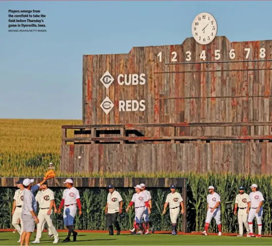  ?? MICHAEL REAVES/GETTY IMAGES ?? Players emerge from the cornfield to take the field before Thursday’s game in Dyersville, Iowa.