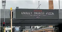  ?? STUFF ?? A billboard at Victoria Park in Auckland announces the launch of the Hell Pizza’s limited edition ‘‘Unruly Tourist Pizza’’.