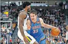  ?? [AP PHOTO/RICK BOWMER] ?? Oklahoma City Thunder forward Mike Muscala, right, drives into Utah Jazz center Ed Davis during Wednesday night's game in Salt Lake City. Utah won the game 100-95.