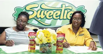  ??  ?? Sweetie Confection­ery’s CEO, Patria-Kaye Aarons (right), and Frozen Delights Distributo­rs (FDD) General Manager Winsome Rowe inking the distributi­on agreement between the two companies.