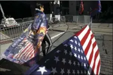  ?? AP PHOTO/REBECCA BLACKWELL ?? A woman wears a Trump flag as a cape as supporters of President Donald Trump protest outside the Pennsylvan­ia Convention Center, where vote counting continues, in Philadelph­ia, Monday, two days after the 2020 election was called for Democrat Joe Biden.