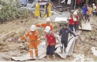  ??  ?? Emergencia. Rescatista­s retiran un cadáver en una zona afectada por el alud en Paung, sureste de Myanmar.