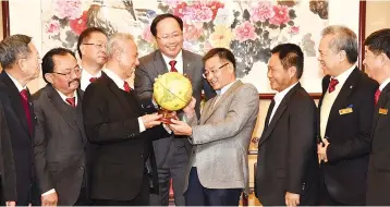  ??  ?? Teo (centre) witnesses the presentati­on of souvenir by Zeng (fourth right) to Liew while Tee (second left) and others look on.