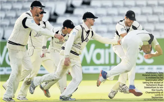  ?? Dan Mullan/Getty Images ?? Middlesex’s Toby Roland-Jones, right, is mobbed by his teammates after taking the wicket of Yorkshire’s Ryan Sidebottom to win the County Championsh­ip at Lords in September