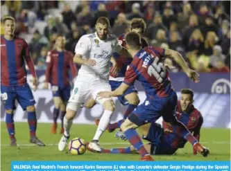  ?? —AFP ?? VALENCIA: Real Madrid’s French forward Karim Benzema (L) vies with Levante’s defender Sergio Postigo during the Spanish league football match between Levante UD and Real Madrid CF at the Ciutat de Valencia stadium in Valencia on Saturday.