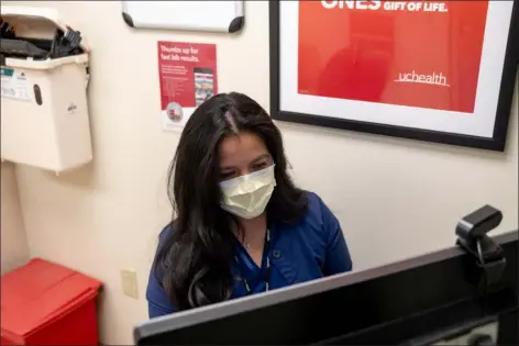  ?? ELI IMADALI, SPECIAL TO THE DENVER POST ?? Uchealth Hispanic Transplant Program nurse Cinthia Lopez Estrada works on a patient’s chart after an appointmen­t at Anschutz Medical Campus in Aurora in December 2022.