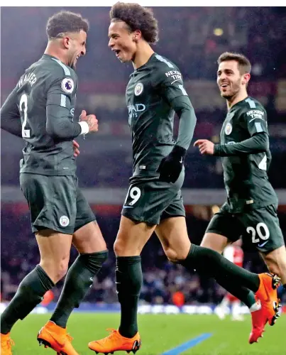  ??  ?? City slickers: Manchester Leroy Sane (centre) celebrates his side’s third goal of the game with Kyle Walker (left) and Bernardo Silva, who opened the scoring (right)