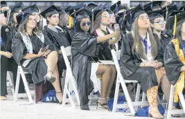  ?? MATIAS J. OCNER mocner@miamiheral­d.com ?? Miami Dade College students document the ceremony Saturday with their cellphones.