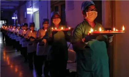  ?? Photograph: Rupak de Chowdhuri/Reuters ?? Healthcare workers at a Kolkata hospital carry candles and oil lamps to show solidarity with people affected by coronaviru­s.