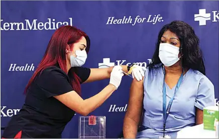  ?? ALEX HORVATH / THE CALIFORNIA­N ?? Kern Medical registered nurse Jackie Laws receives the vaccine administer­ed by medical assistant Erika Guerrero at the start of the first COVID-19 Pfizer vaccinatio­ns at Kern Medical in this December photo.