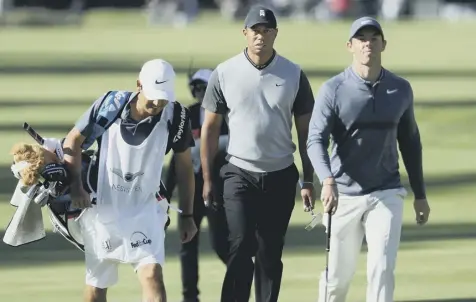  ??  ?? 0 Tiger Woods and Rory Mcilroy walk up the 17th hole during the first round of the Genesis Open at Riviera Country Club.