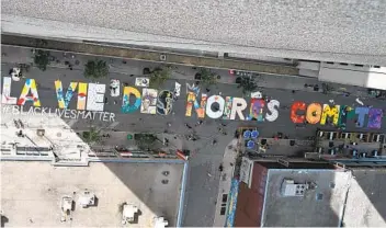  ?? ERIC THOMAS GETTY IMAGES ?? A bird’s eye view Wednesday shows a new Black Lives Matter mural, written in French (La vie des noir.e.s compte), in Saint Catherine Street in central Montreal. The mural will be on display all summer.