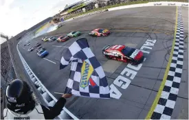  ?? (James Gilbert/getty Images) ?? Ross Chastain, driver of the #1 Moose Fraternity Chevrolet, takes the checkered flag to win the Cup Series GEICO 500 at Talladega Superspeed­way Sunday.