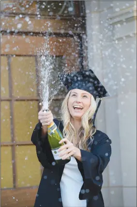  ?? (NWA Democrat-Gazette/Andy Shupe) ?? Kaylea Stevens, a University of Arkansas senior from Rockwall, Texas, laughs Thursday as she sprays champagne in her mortar board and graduation gown while taking photograph­s on the university campus in Fayettevil­le. Stevens is set to graduate in December and doesn’t plan return to in-person instructio­n on campus after the Thanksgivi­ng break because of the pandemic. Go to nwaonline.com/201120Dail­y/ for today’s photo gallery.