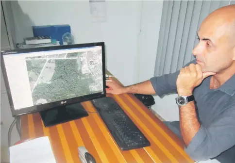  ??  ?? Pedro Correa, director of the environmen­t in the Paranaita city government, looks at a photo of the city surrounded by forests, on his computer screen. Originally from the southern state of São Paulo, he worked for a few months on the constructi­on of...